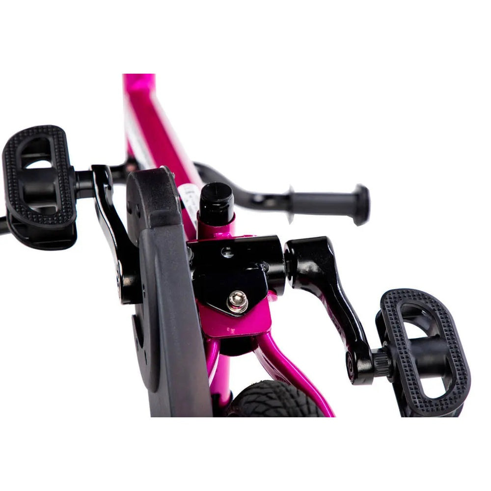 STRIDER 14X Easy Ride Pedal Conversion Kit on pink frame, with black pedals attached for simple riding.