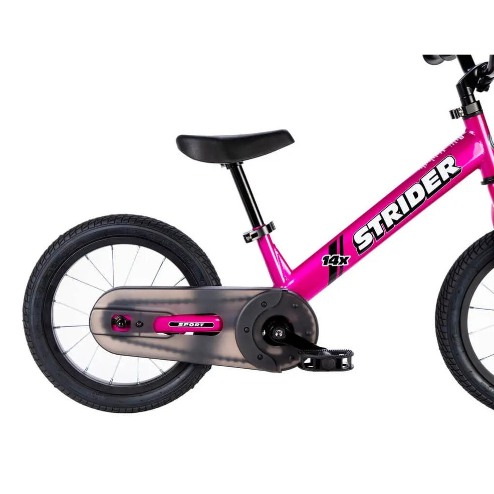 Strider 14X Easy Ride Pedal Conversion Kit on bright pink Strider bike, showing pink drivetrain cover and visible pedals.