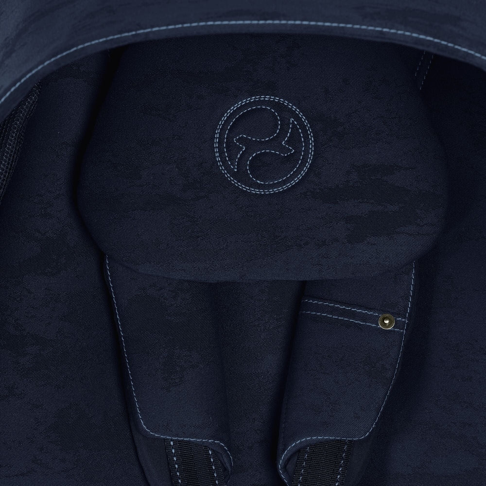 Studio product image of the Cybex Platinum Mios 3 Stroller Rebellious Luxury Denim Blue dark navy denim fabric with light blue contrast stitching and circular logo embroidery on a Cybex MIOS 3 stroller.