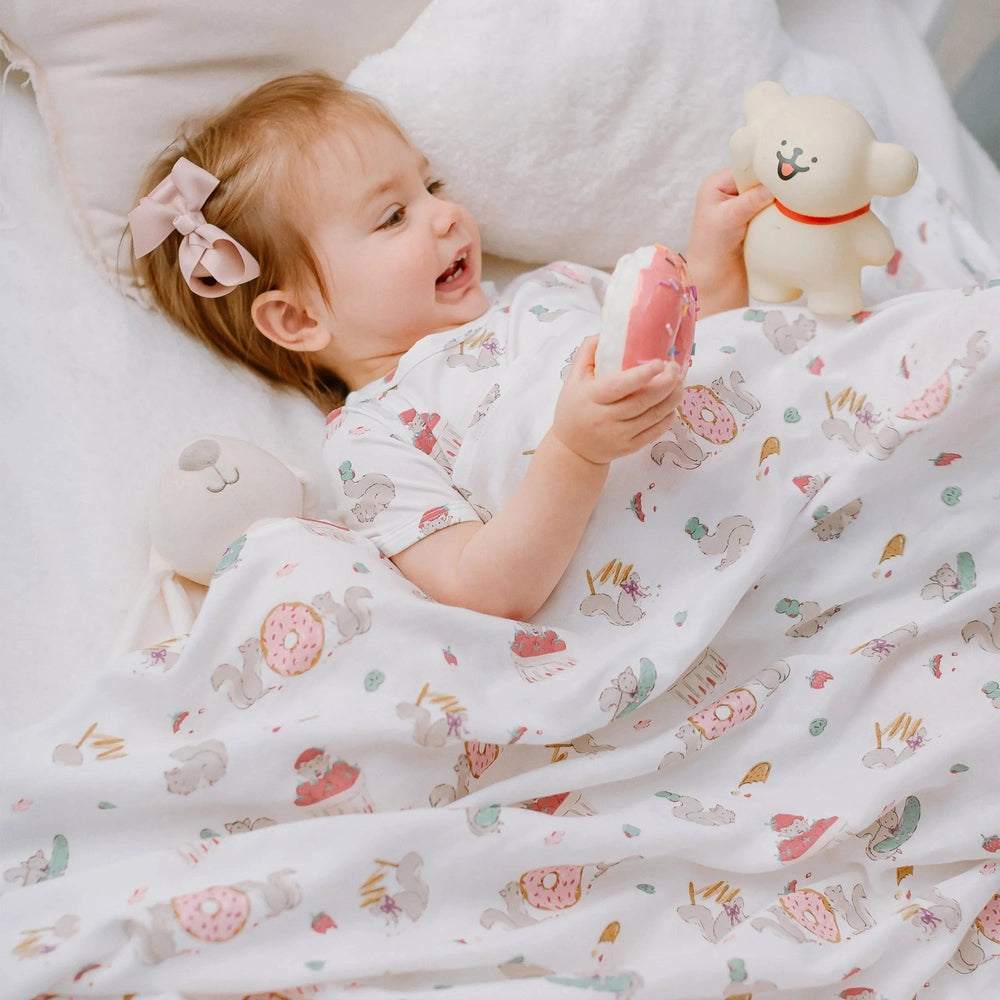 NEST DESIGNS Nest Designs Swaddle Blankie Very Squirrelly illustrated squirrels with donuts in scattered pattern img 2/6