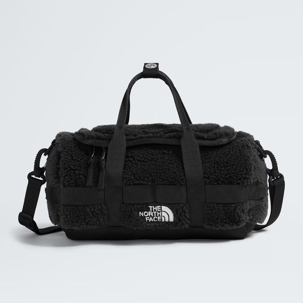 The North Face Base Camp High Pile Mini Bag in black fleece, compact duffel with top handles and shoulder strap.