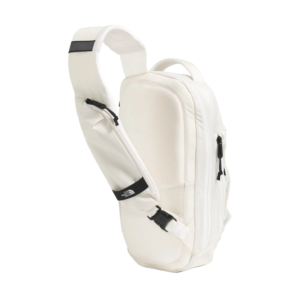 The North Face Borealis Sling Bag in Cream with black zipper accents.