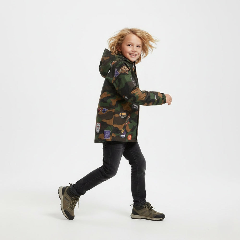 Child wearing a camouflage jacket with patches on a white background