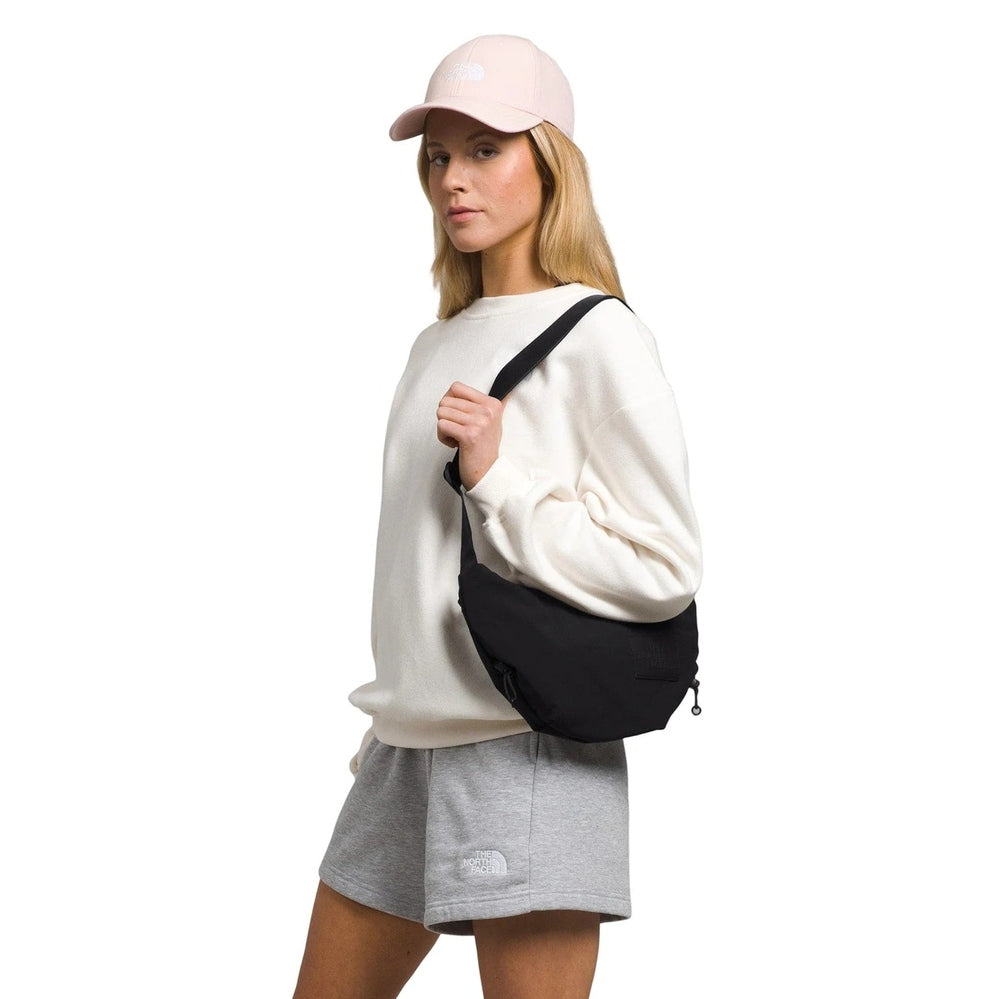 The North Face Women's Never Stop Crossbody Bag in Black worn over the shoulder.