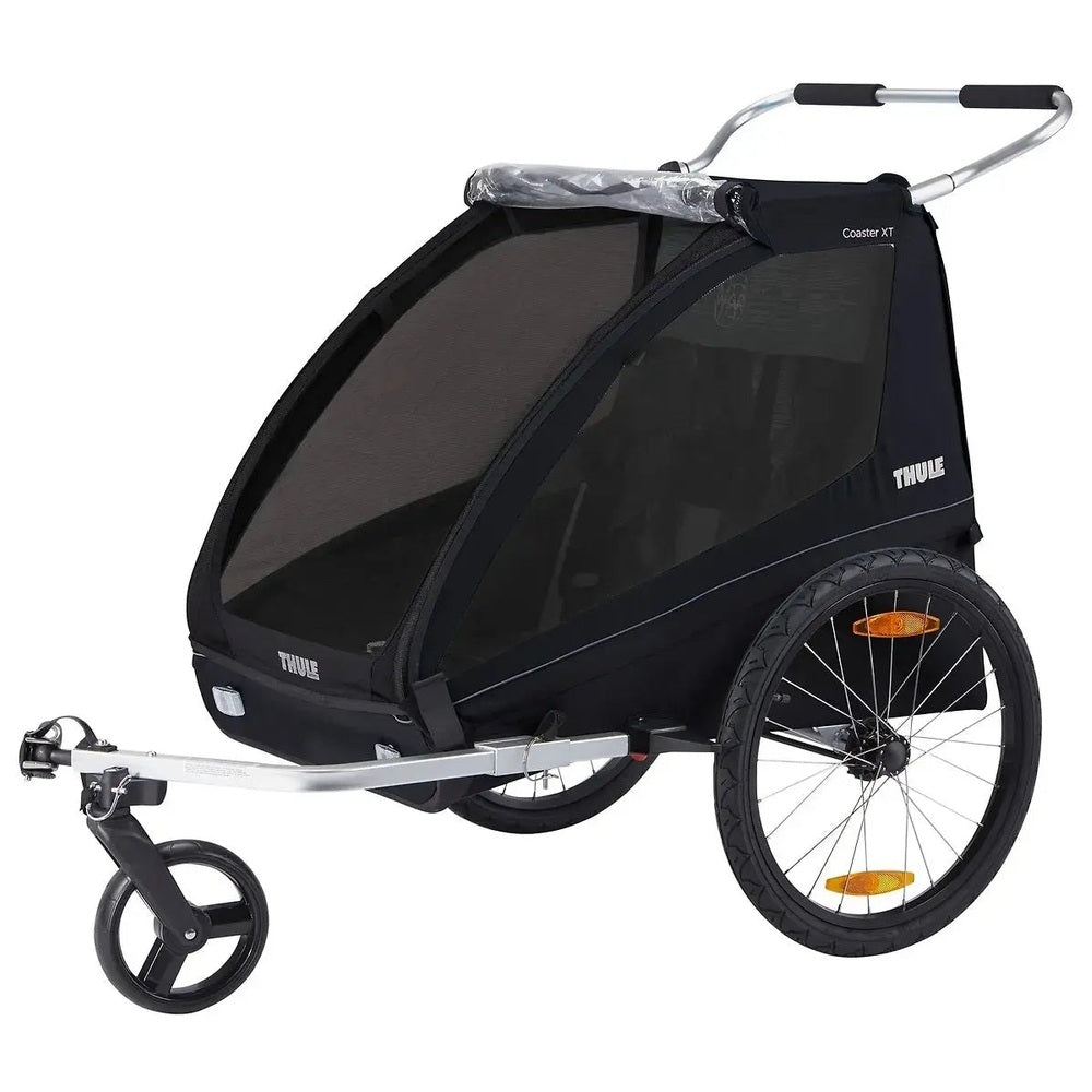 Thule Coaster Xt bike trailer in black with mesh canopy and silver frame, hitched to a tow bar.