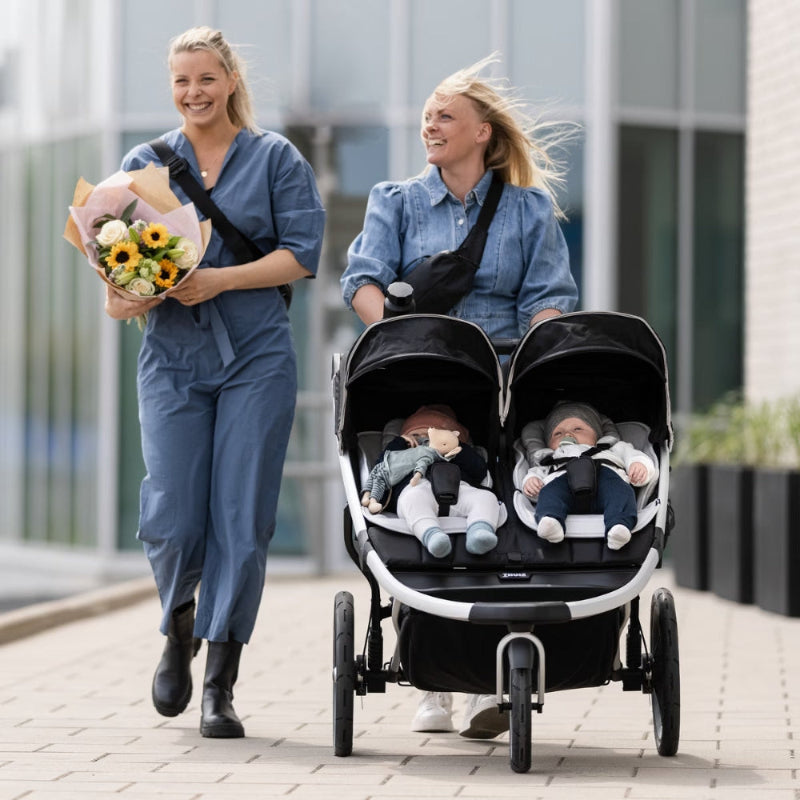 Thule Newborn Inlay Gray stroller accessory on a twin stroller with two infants