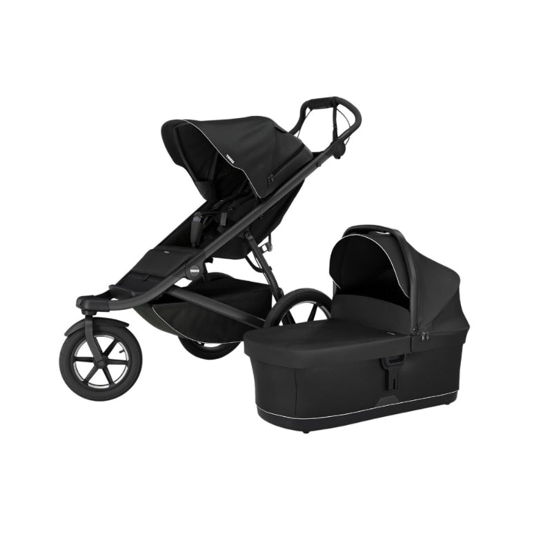 Thule Urban Glide 3/4 Bassinet in black attached to a stroller with canopy, showing easy attachment.