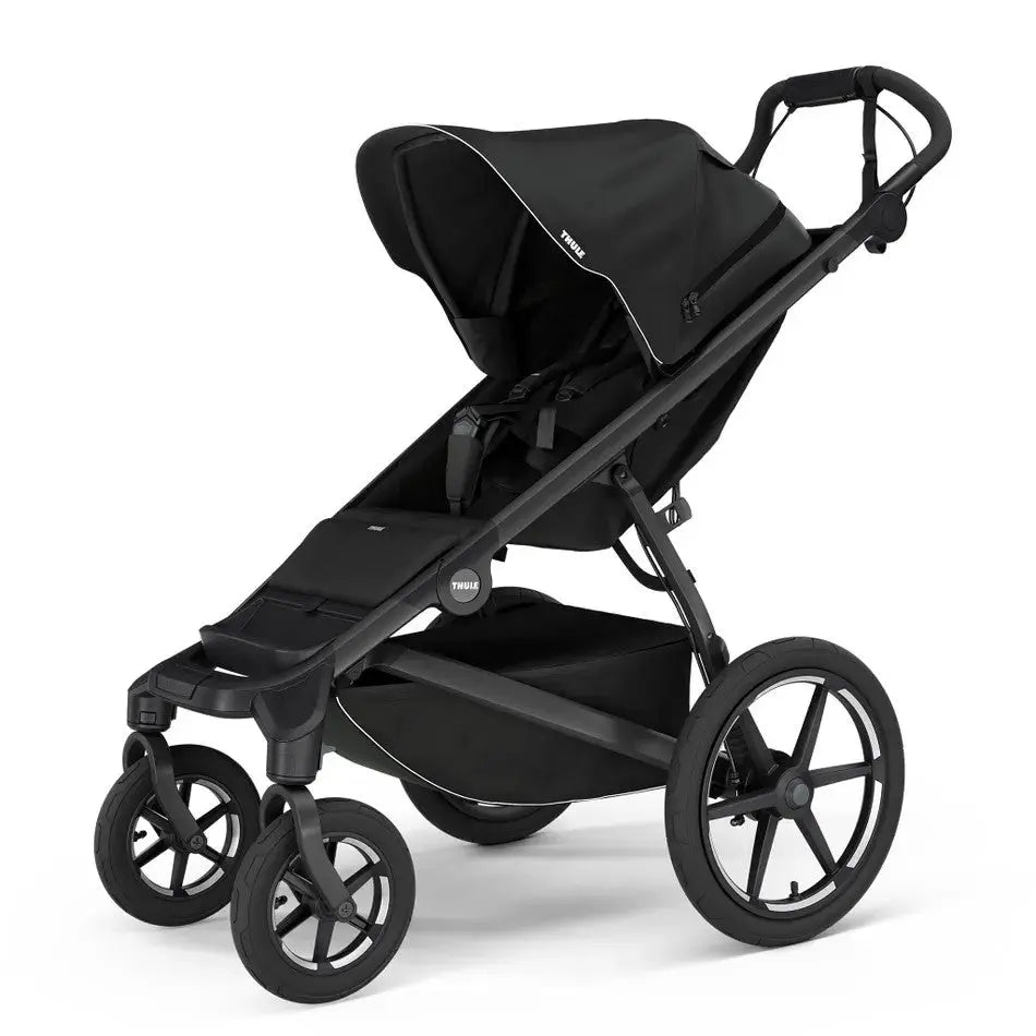 Thule Urban Glide 4-Wheel stroller in black with canopy; four large all-terrain wheels visible.