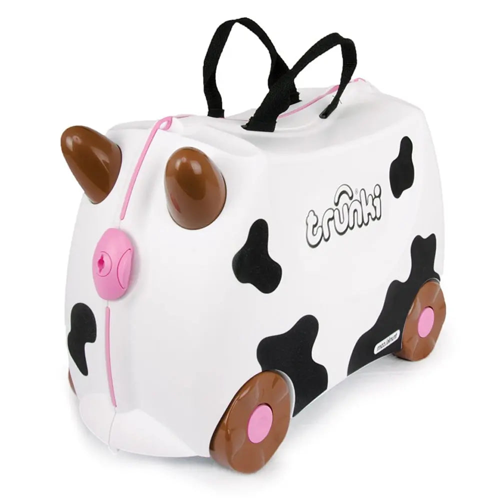 Trunki Ride-On Suitcase cow-print white with pink accents; brown wheels roll and top carry handles show easy travel.