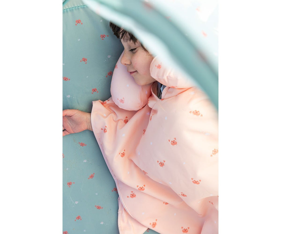 Child resting against a Tutete travel pillow beneath a canopy