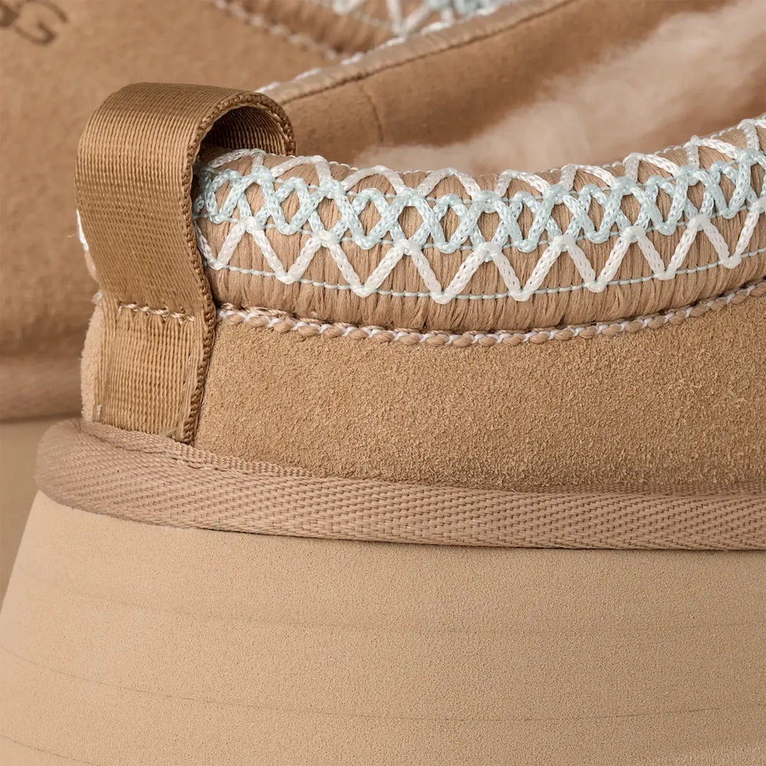 UGG Tazz II in Sand, close-up of UGGbraid trim and rear pull tab