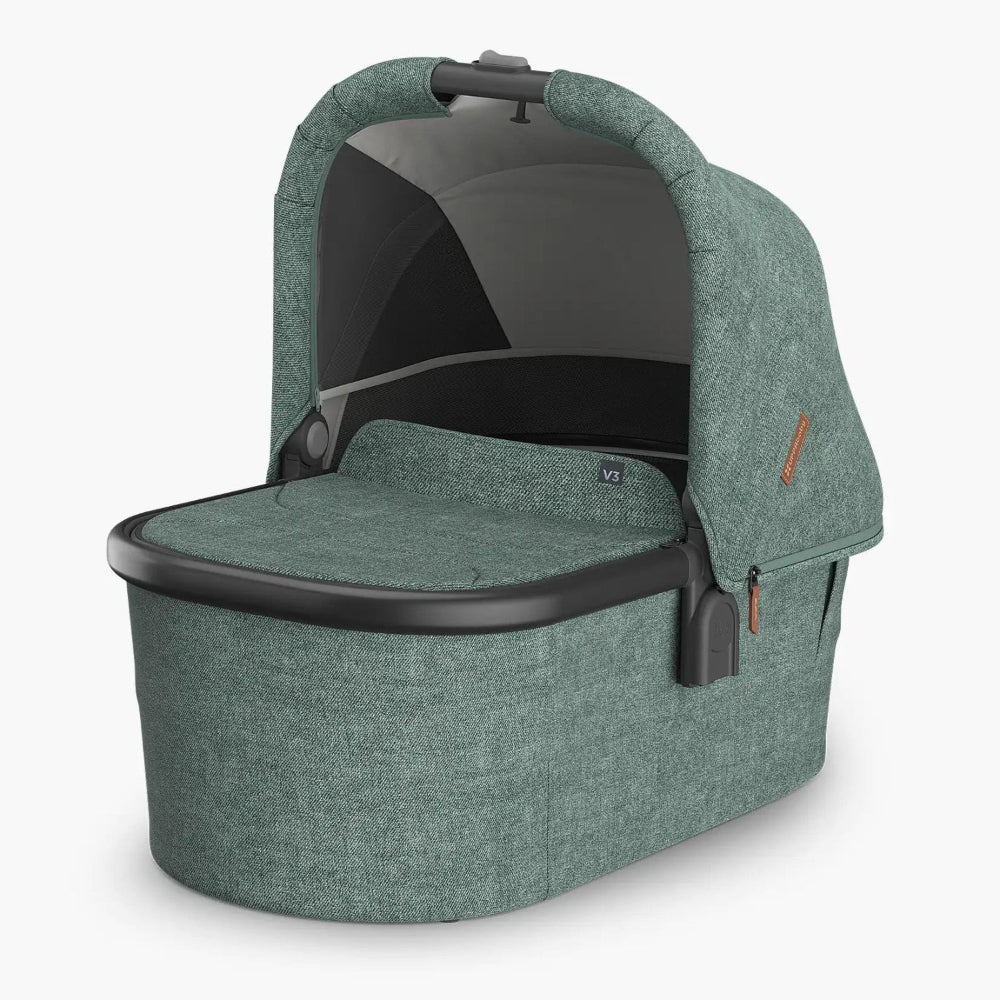 Uppababy Bassinet V3 in green fabric with raised canopy, mesh panel, and sturdy carry handle.