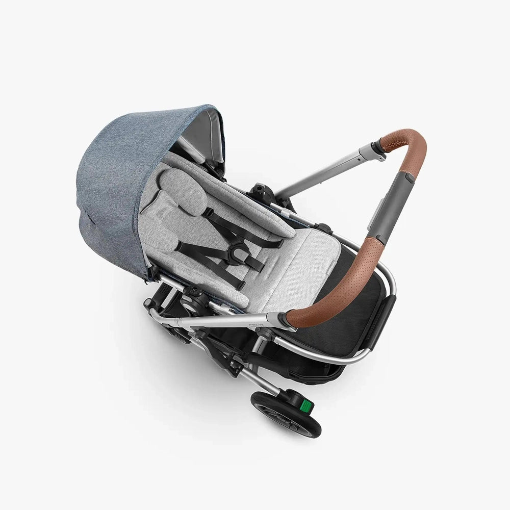 Uppababy Infant Snugseat insert in light gray fabric shown in stroller with blue canopy