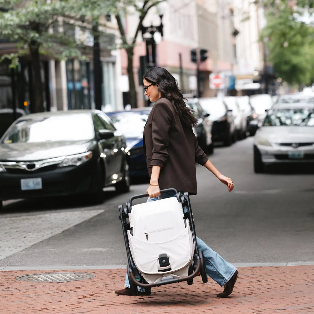 UPPAbaby Kona in Ada folded and carried across a street