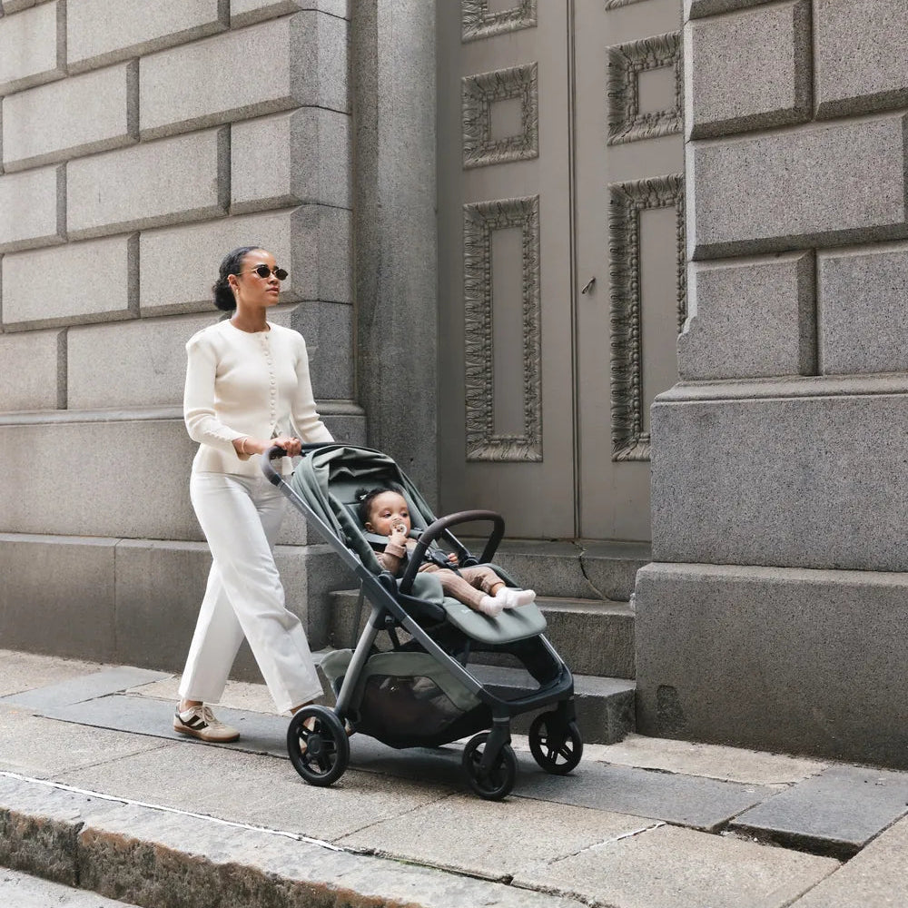UPPAbaby Kona in Evelyn on a city sidewalk