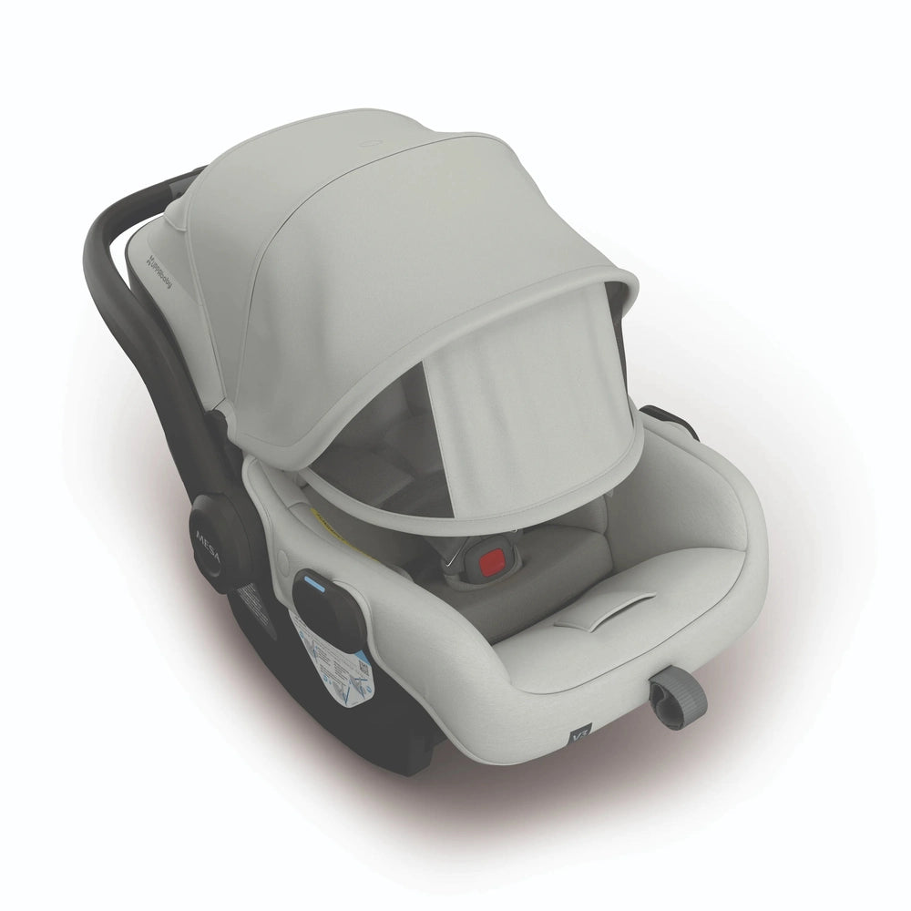 UPPAbaby Mesa V3 infant car seat in light gray with integrated canopy and visible red buckle.