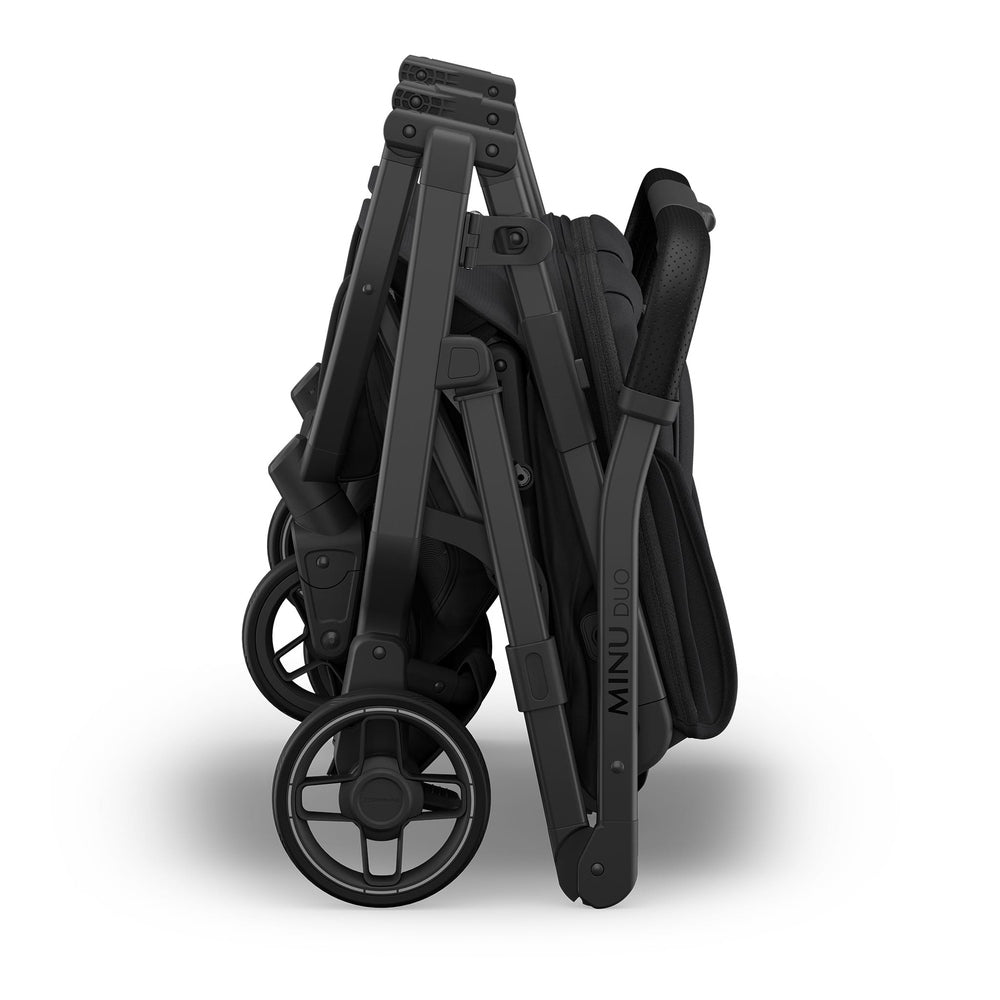 Uppababy Minu Duo Stroller in black, compact folded frame with visible wheels for storage