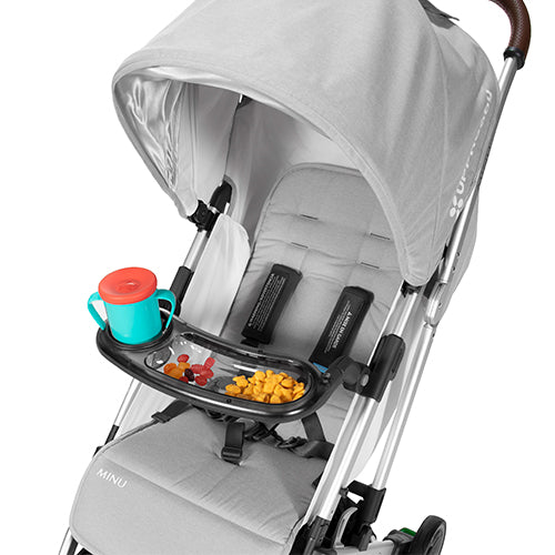 Uppababy Minu Snack Tray attached to a gray stroller, black tray with turquoise cup and snacks