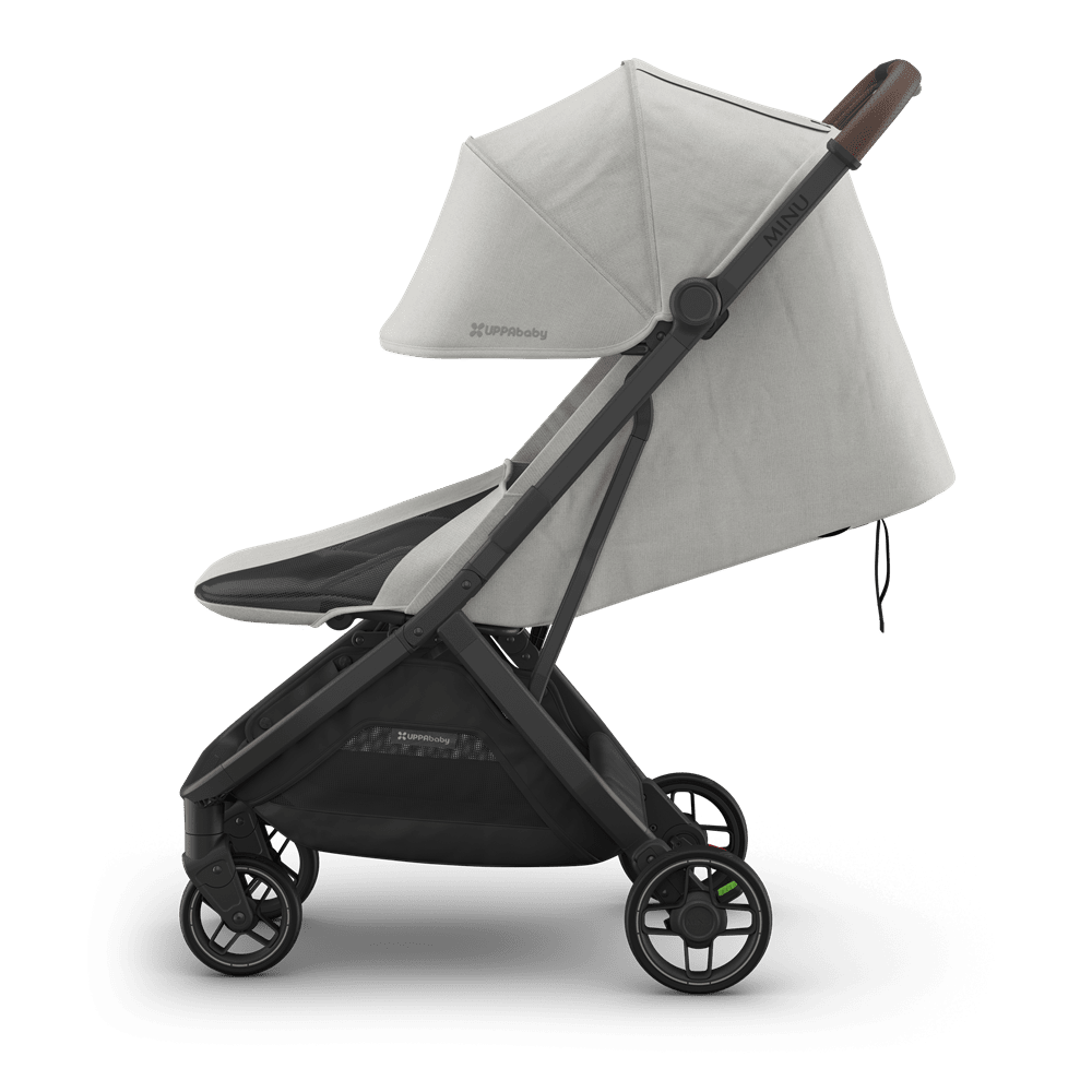 Uppababy Minu V3 stroller with light beige fabric, black frame, and brown leatherette handle