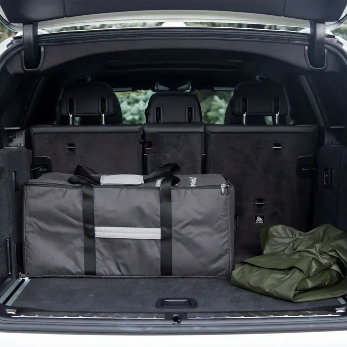 UPPABABY Remi Travel Bag in gray with black straps inside an SUV trunk
