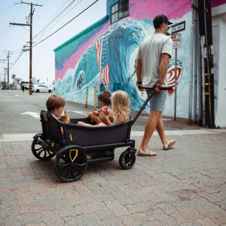 Veer All-Terrain Cruiser XL Wagon pulling three children on a street with mural backdrop