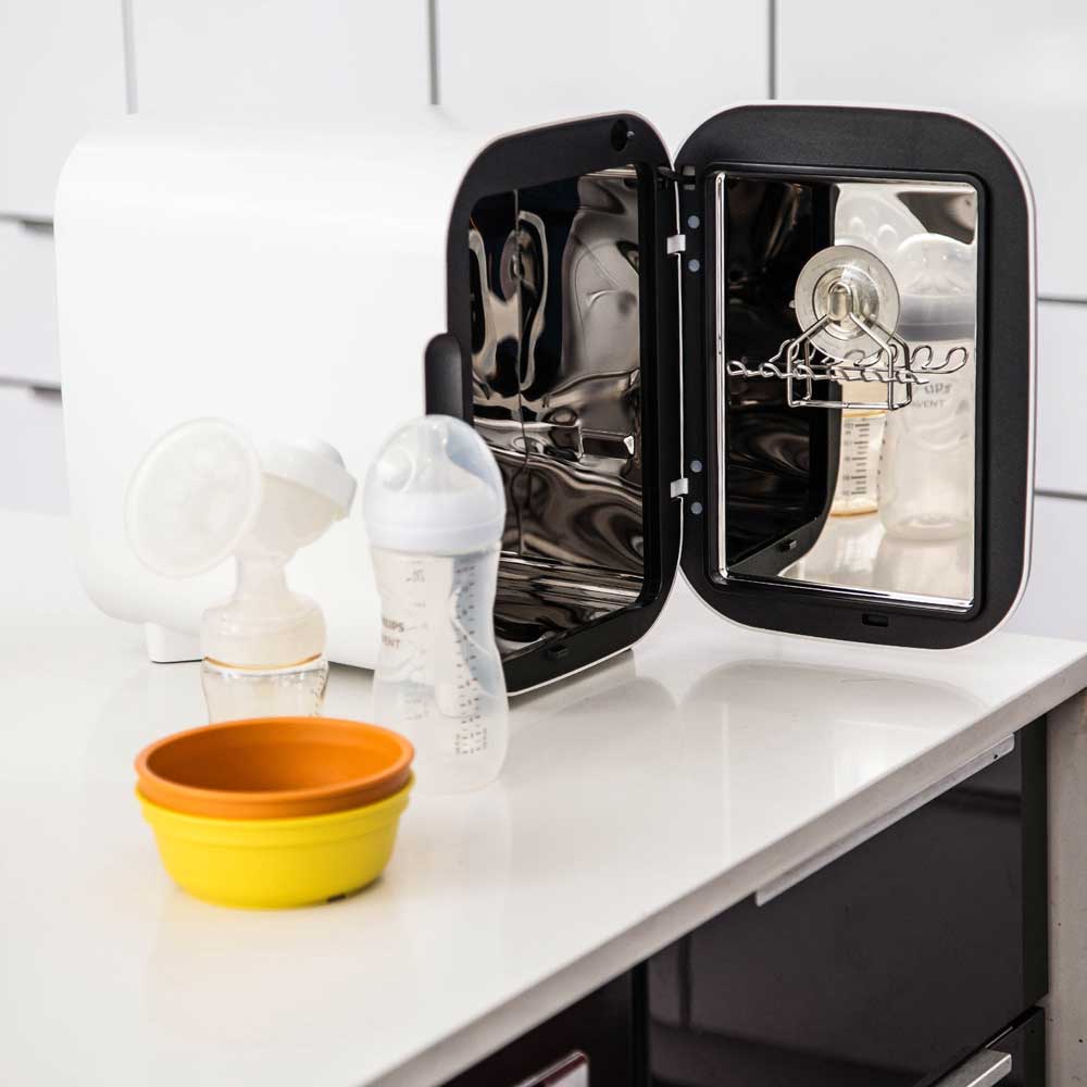 Wabi Baby UV Sterilizer Mini with open door and bottles inside on a kitchen counter