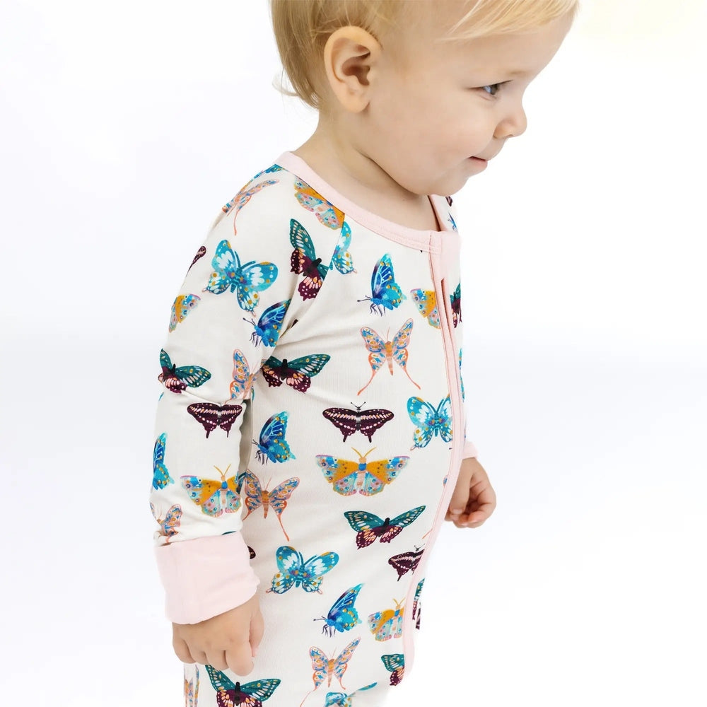 Child wearing a colorful butterfly-patterned outfit on a white background