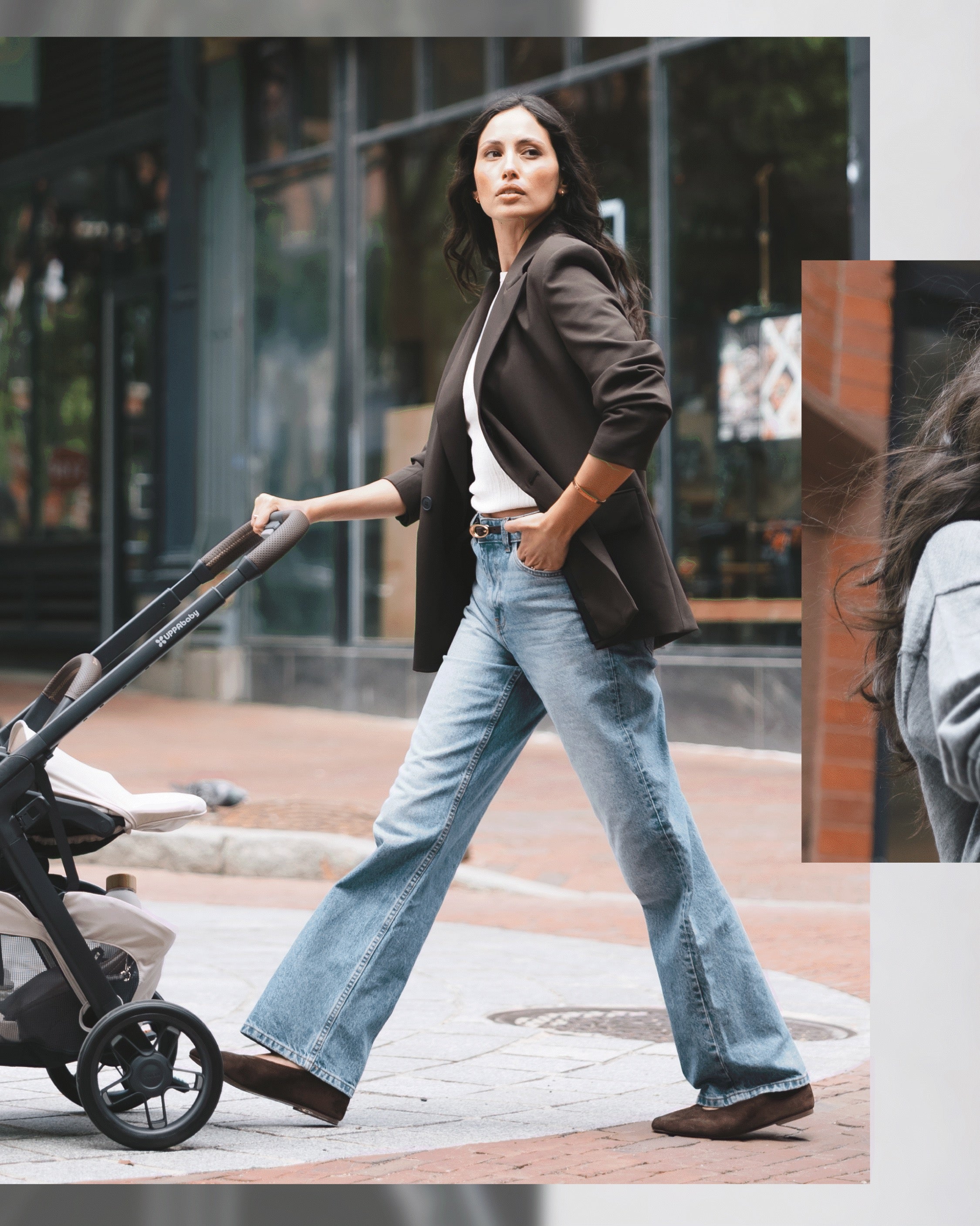 A parent walking through the city with the UPPAbaby Kona stroller